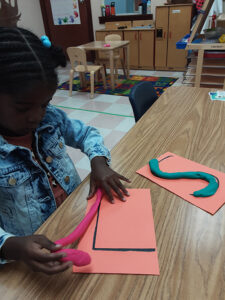 Building fine motor skills while creating play dough letters